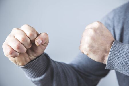 angry man fists on the grey backgroundの写真素材