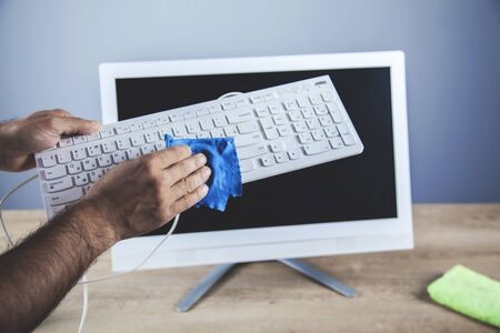 young business man cleaning computer on dark backgroundの写真素材