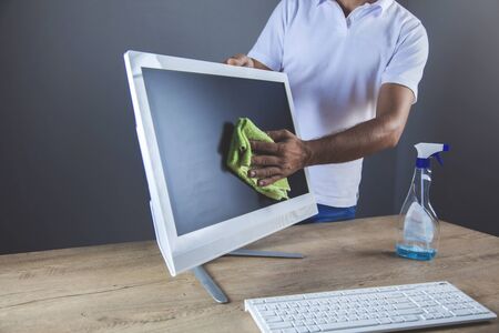 young business man cleaning computer on dark backgroundの写真素材