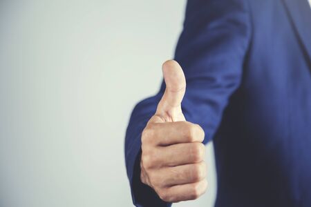 young business man finger thumb on wall background