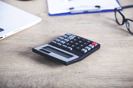 calculator with document and glasses on desk