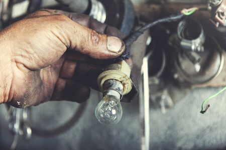 man worker hand holding bulb in garageの写真素材