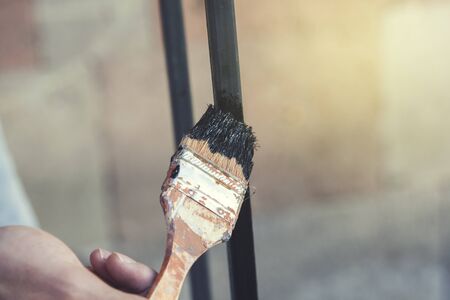 man hand holding paint brush in nature