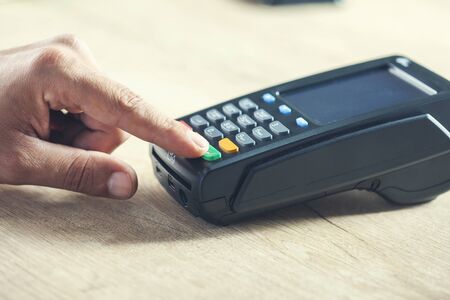 man hand payment terminal on the deskの写真素材