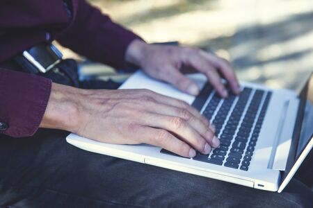 man hand holding white computer in natureの写真素材