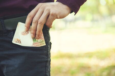 man hand money on pocket in natureの写真素材