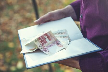 man hand money on the book in natureの写真素材
