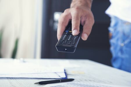 man hand remote control on desk background