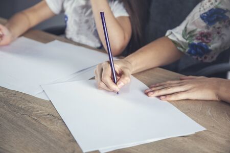 two girl painting on paper on the desk