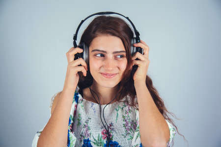 young woman hand earphone on gray backgroundの写真素材