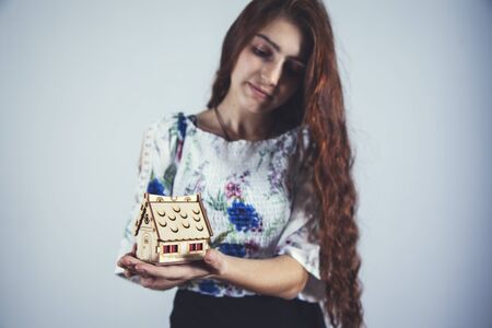 young girl hand  holding wooden house modelの写真素材