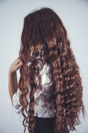 young girl hand long hair on gray backgroundの写真素材