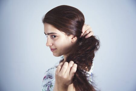 beautiful woman hand in hair on gray backgroundの写真素材