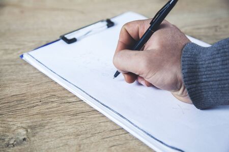 man hand pen with notepad on deskの写真素材