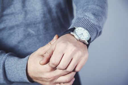 man hand watch on the gray wall background