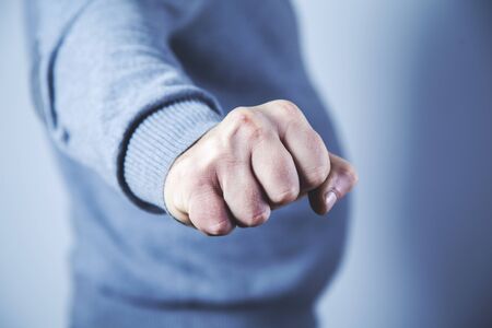 young angry man fist on gray backgroundの写真素材