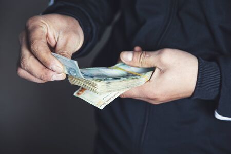 man hand holding money on gray abckground