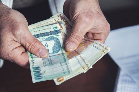 man hand holding money on gray abckground