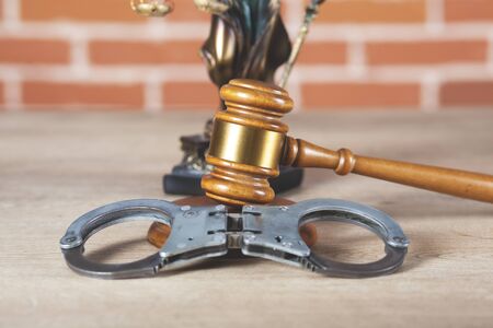 handcuffs with judge on the wooden table