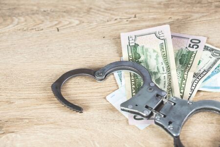 handcuffs on money on the wooden table