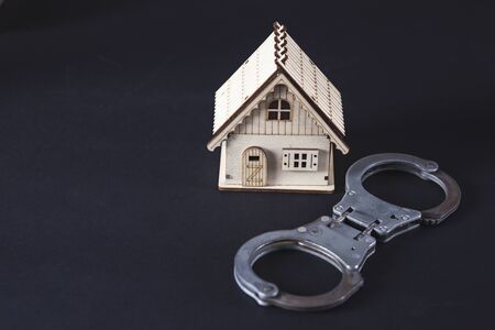 house model with handcuffs on black tableの写真素材