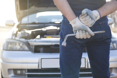 Mechanic holding a wrench in a workshop on the streetの写真素材