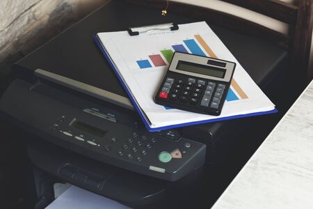 Close up of an office table with printer and calculator on it