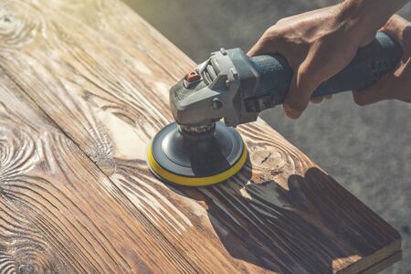 young worker man polishing boards on wooden tableの写真素材