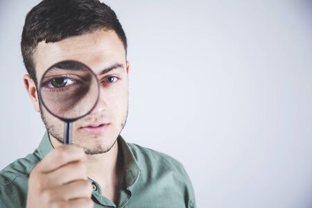 man hand magnifier on eye in studioの写真素材