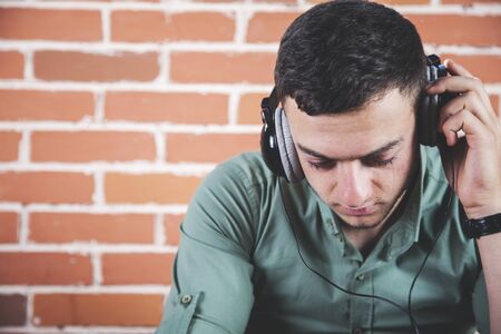 young man hand or ear earphone in studioの写真素材