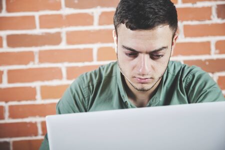 sad man notebook on the brick wall backgroundの写真素材