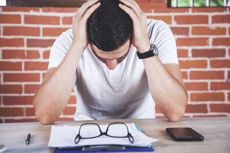sad man with glasses on document on the desk