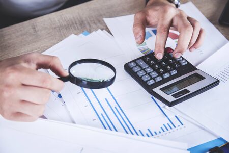 man hand magnifier with document on the desk