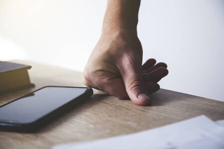 man hand with phone on the table