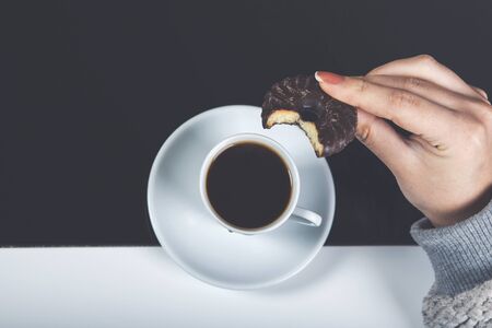 Young woman drinks coffee with cookiesの写真素材