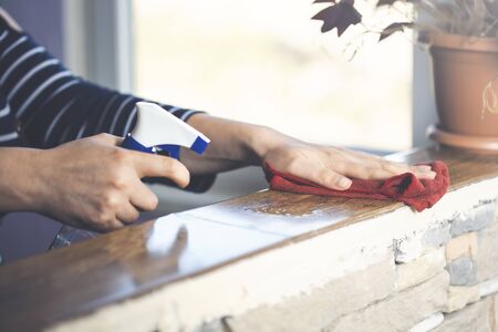 young woman cleans the table with a sanitizerの写真素材