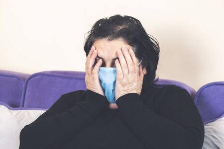 Elderly woman suffering from headache at homeの写真素材
