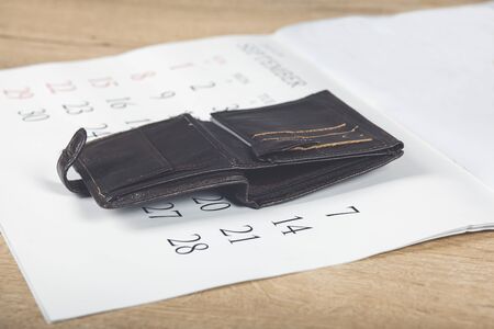 Wallet with coins on a white calendar background