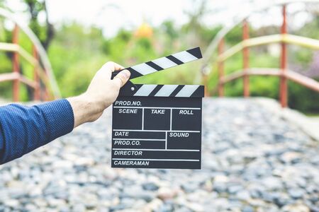young businessman hand holding movie sign on a park backgroundの写真素材