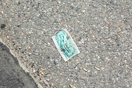 An used light blue face mask drop on the road, the face masks used for the anti-coronavirus that were used were left on the floorの写真素材