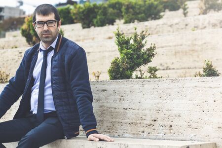 Young businessman working sited in a bench at the city parkの写真素材