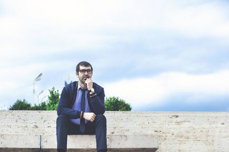 young businessman sitting in the park after work