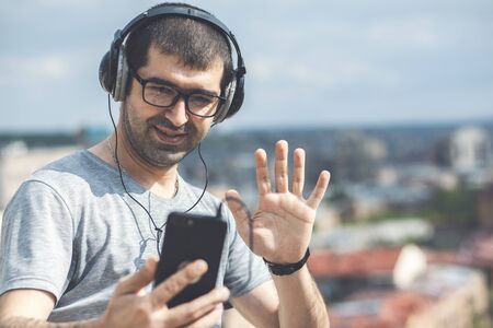 young man in headphones listening to music in the park