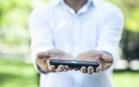 man hand holding smart phone in the natureの写真素材