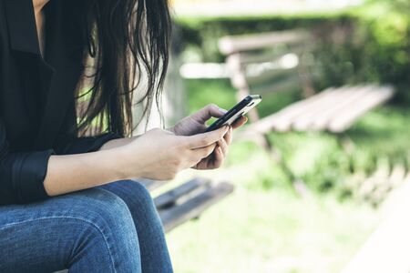Beautiful young woman using smartphone in the natureの写真素材
