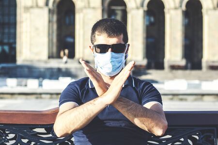 A portrait of the young man on the protective mask  showed stop to coronavirus in the cityの写真素材
