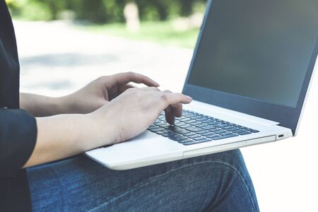 business woman working on laptop while sitting on bench