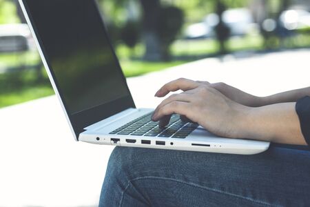 business woman working on laptop while sitting on bench