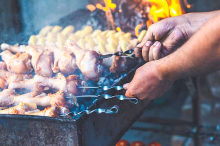 A man fries meat while cooking barbecue. Cooking meat in nature. Close-upの写真素材