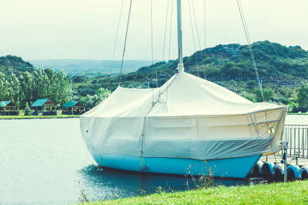 Motorboat covered in a rain tarp and wooden pier
